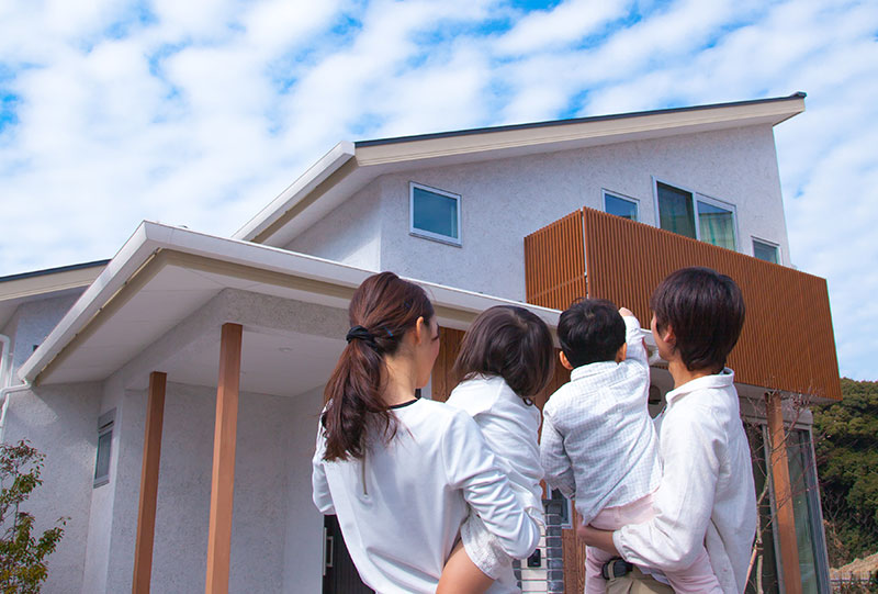 新築一戸建ての前に立つご家族